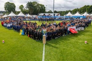 Photo de la cérémonie d'ouverture de la FCGM Champions League 2024 U10 à Guipry-Messac avec sur la pelouse la présence de l'ensemble des joueurs et coachs venus de toute la France mais aussi de Belgique, des Pays-Bas, d'Angleterre, d'Italie et même des Etats-Unis.